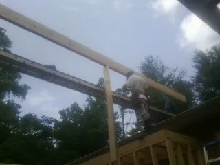 Carpenter setting a ridge beam over a new addition frame — Ice Dam Removal by Roofing Brothers in Bliss