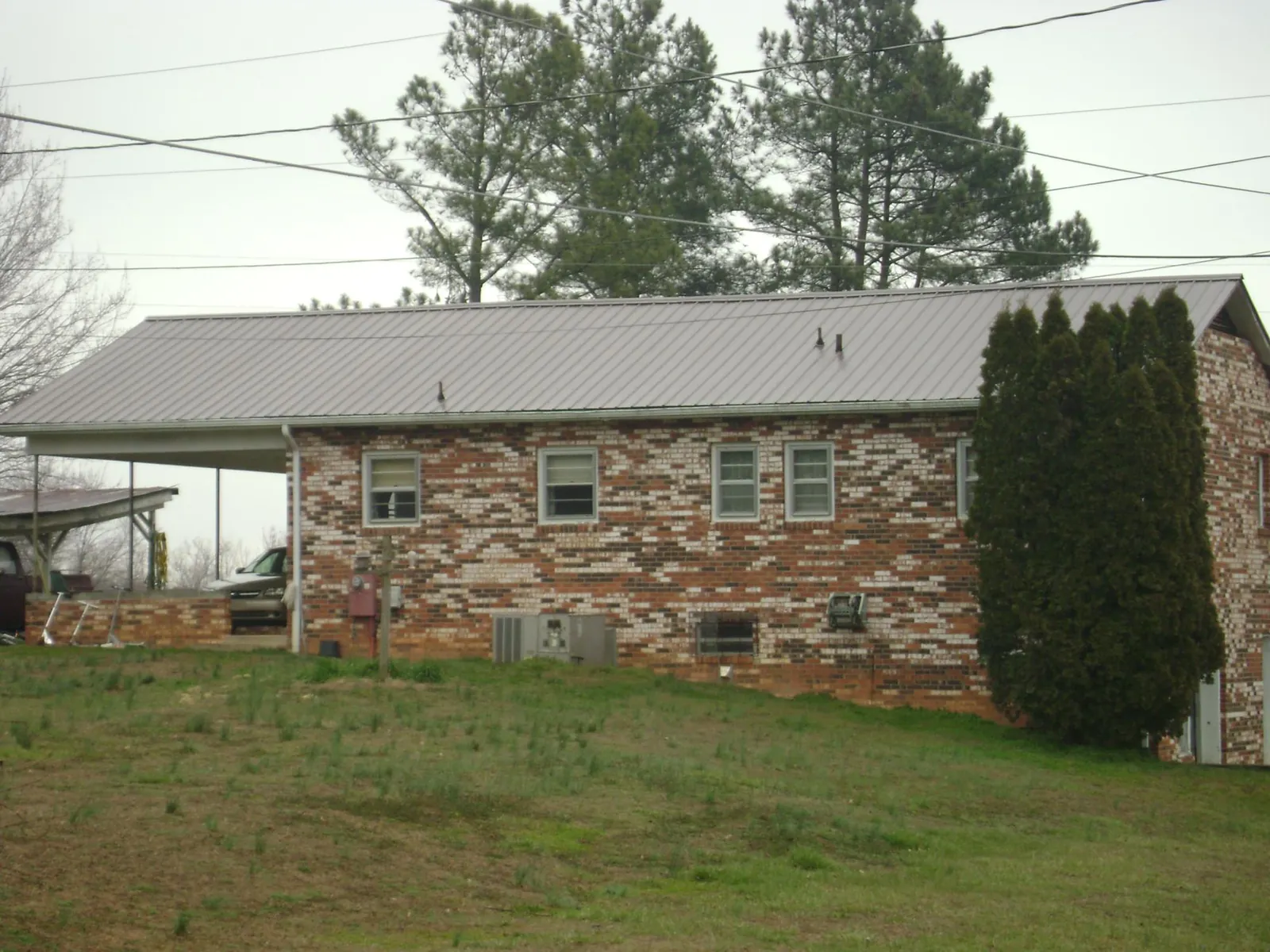 Gray metal roof on a brick split level home with a carport in Bliss