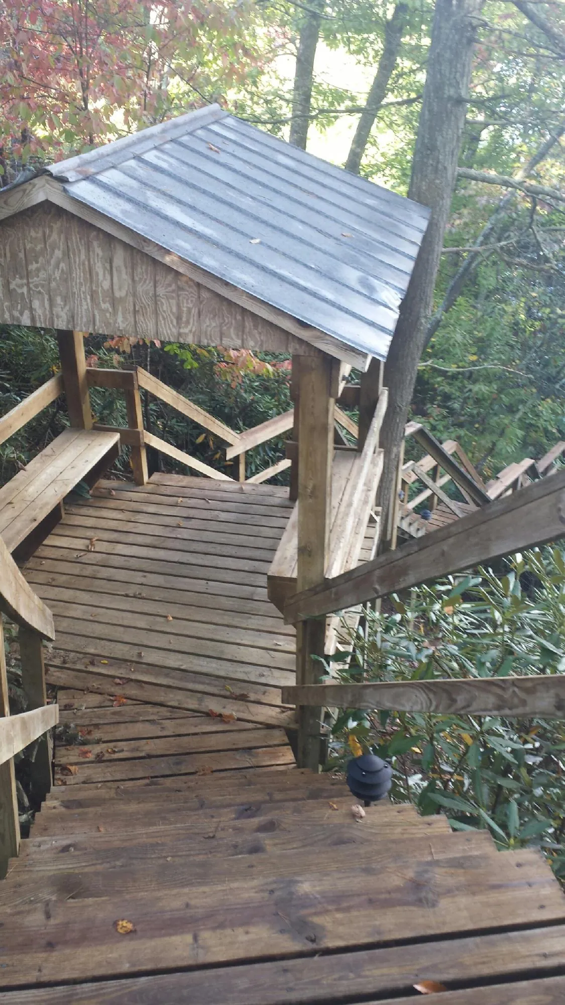 Metal roofed shelter over wooden steps on a wooded walkway — Skylight Repair & Installation work by our crew in Bliss